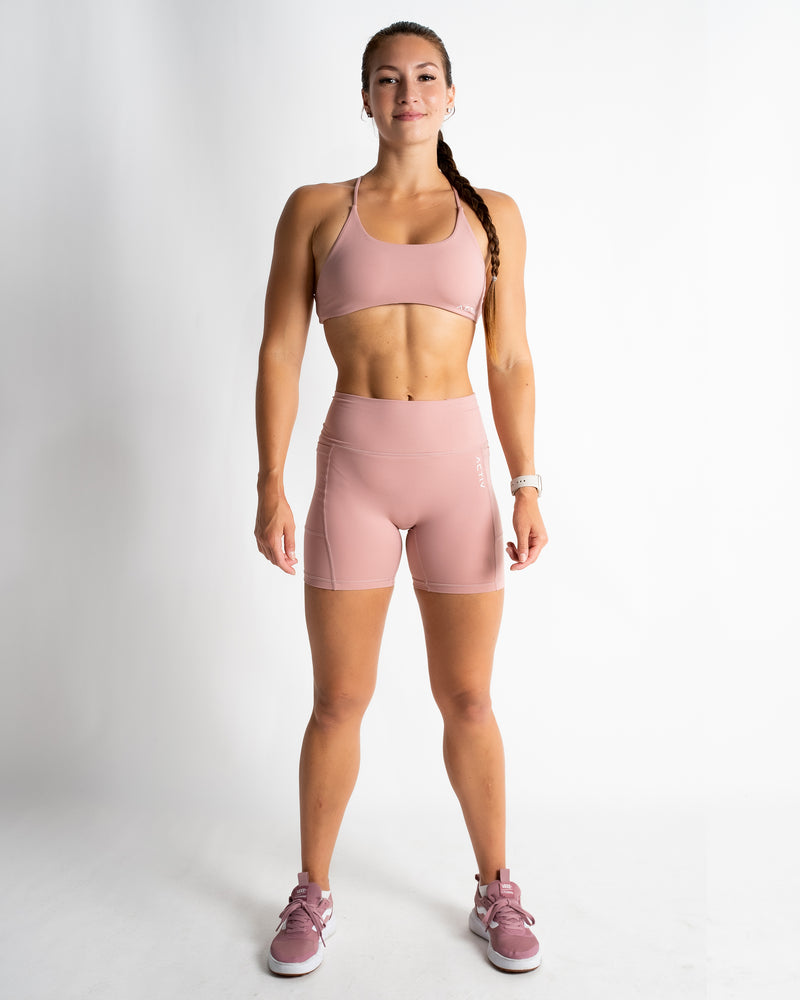 Happy and beautiful fit woman wearing pink fitness bra while